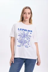Remera blanca de algodón con estampa azul de una palmera, un pez y el texto "La Palma Beach Isla Bonita Canarias Spain".