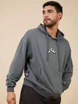 Canguro gris con capucha y cordones ajustables, bolsillo tipo canguro y logo de la marca estampado en el pecho.