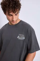 Remera gris oscuro de corte holgado con estampado pequeño en el pecho.