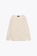 Sweater color crema de tejido de punto grueso, con cuello redondo amplio y mangas largas.