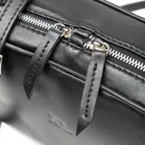 Bandolera negra de cuero con correa ajustable y cierre de cremallera doble.