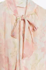 Vestido midi de cuello subido con lazada y escote pico. Manga larga, cintura elástica y estampado floral.