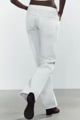 Jeans de mezclilla azul oscuro con efecto lavado, tiro bajo y pierna ancha extra larga. Modelo de cinco bolsillos con cierre frontal de cremallera y botón metálico.