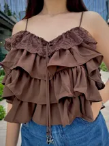 Blusa color amarillo manteca con breteles finos, escote en V con detalle de encaje y volados en capas.