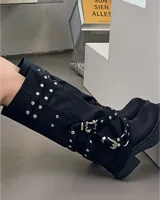 Botas negras de caña alta con hebillas y taco bajo.