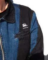 Camisa de denim negro y azul con cortes curvos y simétricos, cierre frontal de alpaca, cuello en cuero vacuno y bolsillos delanteros con bordado del logo Temblad.