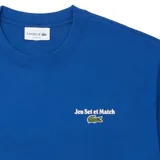Remera azul de manga corta con cuello redondo, confeccionada en tejido de punto de algodón. Presenta un pequeño logo de Lacoste bordado en el pecho.