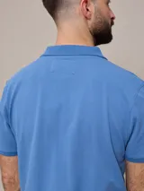Remera polo color beige, de piqué de algodón, con cuello clásico y tapeta de dos botones.