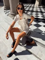 Mono corto color beige confeccionado en lino de algodón, con tirantes regulables.