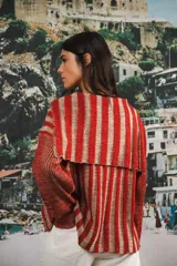 Buzo color beige con rayas horizontales en lurex dorado, cuello con medio cierre, corte oversized y logo tejido en el puño.