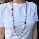 Collar largo con cadena plateada de eslabones y piedras de coral, turquesa y nácar. Incluye dijes en forma de corazón de nácar.