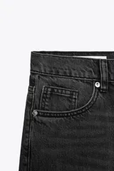 Jeans de tiro medio color azul oscuro, corte wide leg, con trabillas y cinco bolsillos. Cierre frontal con cremallera y botón metálico.