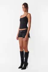Short de jean negro con roturas, tiro medio, cintura con pasacintos, cierre y botón metálico.