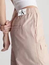 Pantalón cargo recto color rosa claro, con cintura elástica, bolsillos delanteros, traseros y laterales tipo cargo, puños con cordón ajustable y bragueta con cremallera.