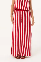 Falda larga tejida a rayas verticales rojas y blancas, con pretina elástica y tajos laterales.