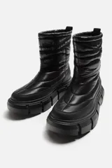 Bota corta color verde militar con diseño acolchado, tirador trasero y suela track negra.