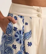 Pantalón wide leg de viscosa con estampado de arabescos en el lateral, cintura alta con elástico en la espalda y cierre con botones.
