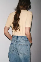 Camiseta color beige de lino con cuello en V y mangas cortas.