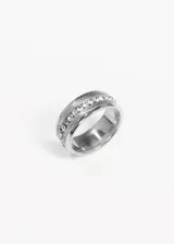 Anillo plateado de acero quirúrgico con diseño calado y strass al centro.