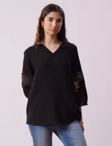 Blusa negra de gasa bambula con cuello a la base y escote en V. Tiene mangas 3/4 amplias con apliques de crochet.