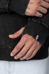 Buzo canguro marrón con capucha, confeccionado en frisa gruesa de algodón con recortes y calce oversize.