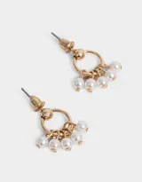 Aros dorados con forma de aro y perlas colgantes.