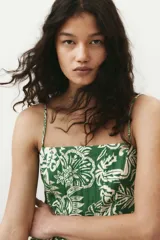 Vestido midi verde con estampado floral blanco, breteles finos ajustables, escote cuadrado, espalda fruncida y falda con vuelo.