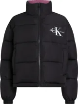 Campera reversible de poliéster impermeable color borgoña con logo Calvin Klein Jeans estampado en blanco. Un lado es liso y el otro tiene un diseño con monogramas.