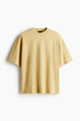 Remera color mostaza de algodón de peso medio, corte oversized, con cuello redondo ribeteado, hombros caídos y bajo recto.