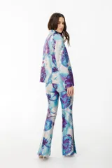 Pantalón de vestir con leve evasé y tajo en laterales, con estampado floral en tonos celeste, blanco y violeta.