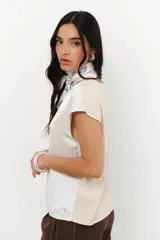 Blusa de manga 3/4 y cuello redondo, confeccionada en lino con acabado metalizado en tono beige o dorado claro.