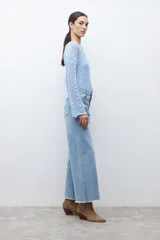 Jean de mujer tiro alto, color azul claro lavado, corte ancho (wide leg) y largo con terminación deshilachada en el ruedo.