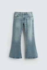 Pantalón de jean celeste, de tiro medio, corte ajustado en la parte superior y acampanado desde la rodilla. Tiene cinco bolsillos, efecto lavado y bajo irregular.