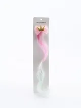 Broche con extensión de pelo sintético en degradé de rosa a verde, decorado con corona dorada y moño de tul con lentejuelas.