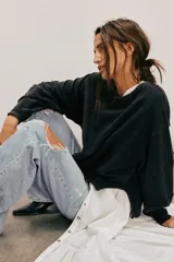 Camiseta de manga larga color verde oliva, con textura acanalada y silueta holgada extragrande. Presenta escote redondo, hombros caídos y puños anchos.