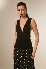 Top sin mangas color negro, ajustado al cuerpo, con escote pronunciado en V y frunces en el busto.