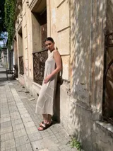 Vestido midi color beige, de corte recto y sin mangas, con estampado de líneas blancas.