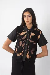 Camisa negra de lino con frente tejido a crochet a mano, con cuello clásico, cierre con botones dorados y mangas cortas.
