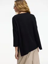 Sweater color crema de corte amplio, con cuello redondo y tajos laterales.