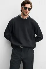 Sweater negro de punto con cuello redondo y manga larga. Presenta parches combinados a tono en hombros y codos.