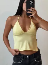 Top marrón con breteles finos que se atan al cuello, escote en V y corte ajustado.