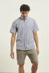 Camisa de manga corta a rayas verticales azules y blancas, con cuello abotonado y bolsillo en el pecho.