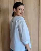 Blusa blanca de mangas 3/4 abullonadas con escote en V.