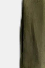 Mono corto color verde militar confeccionado en lino 100%. Tiene cuello redondo, sisa y espalda descubierta. Presenta bolsillos laterales ocultos en costuras.