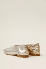 Chatas color beige de cuero vacuno, con talón suave y capellada metalizada.