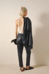 Pantalón babucha de cuero ovino color negro, con bolsillos en el frente, cintura elastizada y tira de ajuste con terminales metálicas.