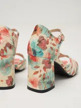 Sandalias de charol con estampado floral, taco cuadrado y correa fina en el tobillo.