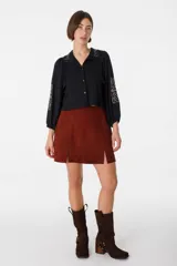 Minifalda marrón de cuero gamuzado, con tajo frontal y cierre trasero invisible.