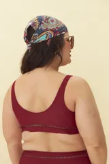 Top de bikini color borgoña con escote redondo y detalle de calado en el bajo busto.