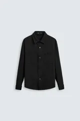 Sobrecamisa negra de tejido con elasticidad, cuello solapa, manga larga con puño abotonado, bolsillos de plastrón en el pecho y cierre frontal con botones a presión.
